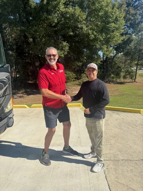 An Absolute Auto Glass team member with another person beside an RV